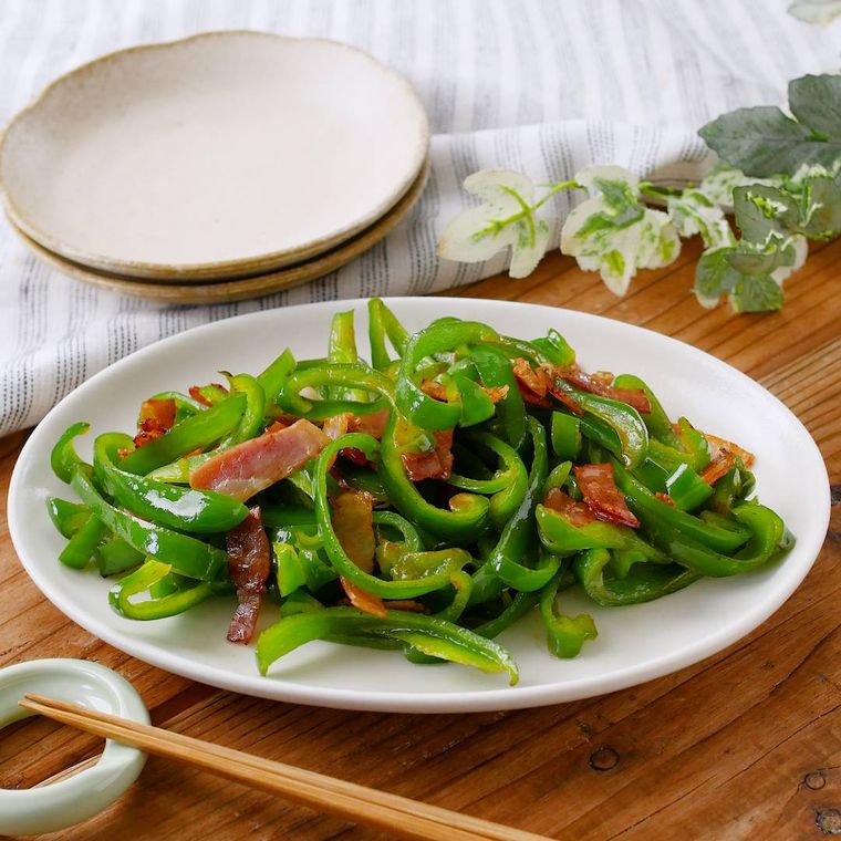 白い皿に盛り付けたピーマンとベーコンのバターしょうゆ炒め