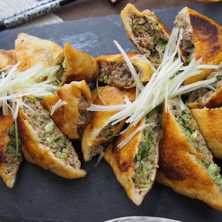 カットした油揚げの餃子風が黒のトレイに盛り付けてある様子