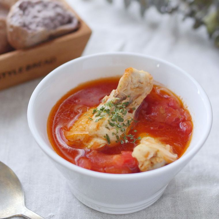 白い器に入った鶏手羽元とトマトのチリスープ