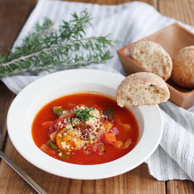 白い皿に盛り付けたシーフードのトマトスープ