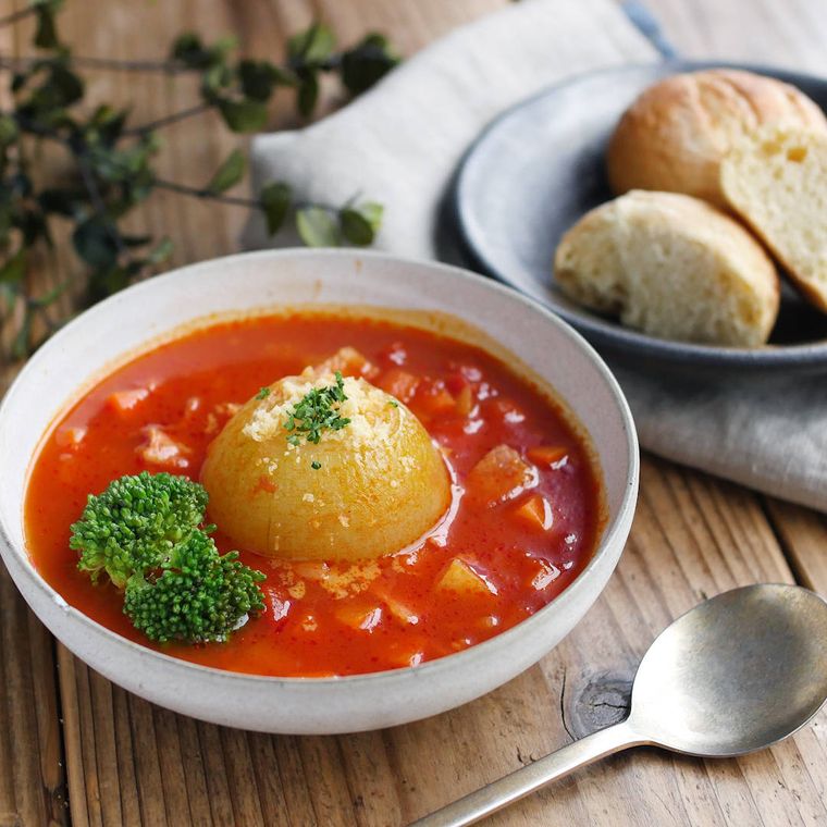 白い器に入った丸ごと玉ねぎのトマトスープ