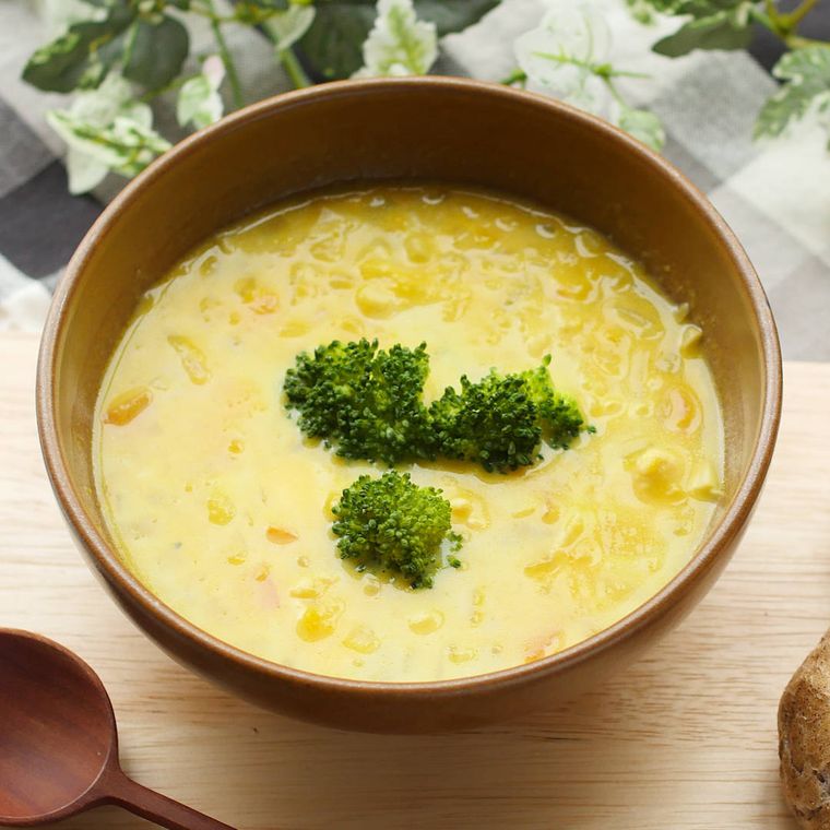 木の器に盛り付けられた、鶏ささみとかぼちゃのスープとスプーン