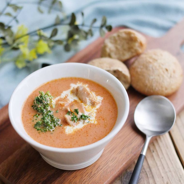 白いお皿に盛り付けられた、鶏もも肉のトマトクリームスープ