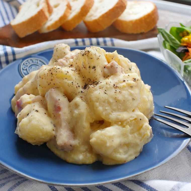 青い皿に盛られたじゃがいもとベーコンのじゃがボナーラ