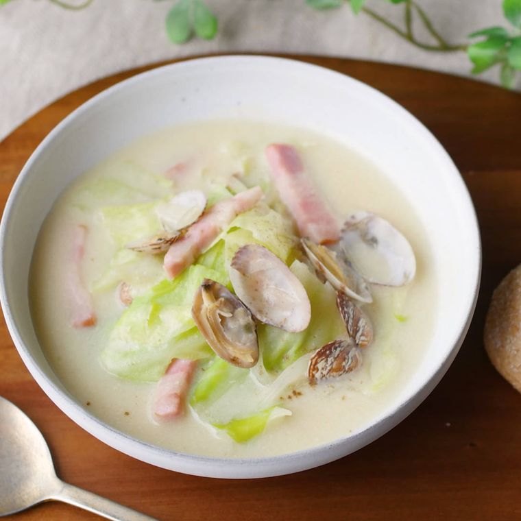 白いスープボウルに盛りつけられたあさりと春キャベツの豆乳スープ
