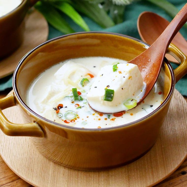 キャラメル色のスープ皿に盛りつけられた絹豆腐の中華風豆乳スープ