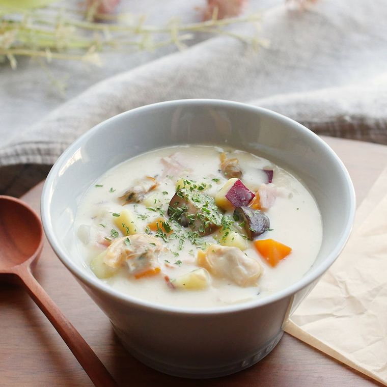 白い陶器のスープ皿に盛りつけられたさつまいもの豆乳クラムチャウダー