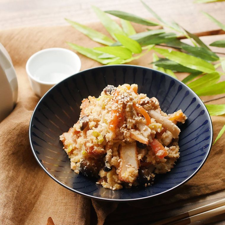 藍色のお皿に盛り付けられたさつまあげ入り卯の花に、白いおちょこととっくりが添えられている