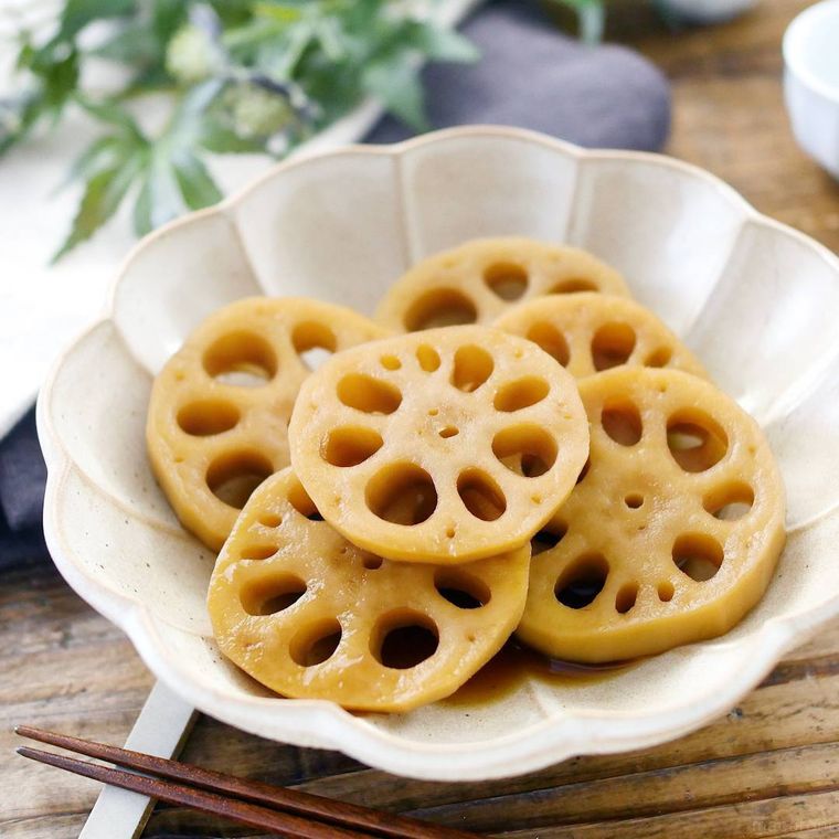 白色の花型の皿に盛られたれんこんの煮物