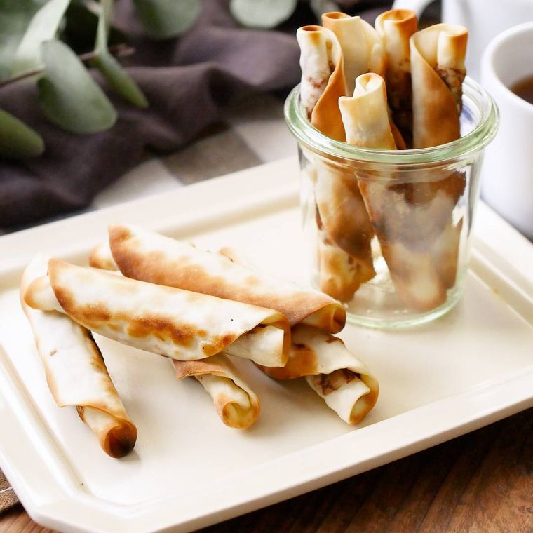 白い角皿に盛りつけられているシガレット風のチョコクッキー巻き