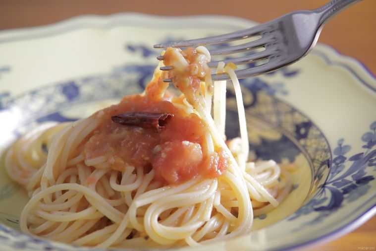 白地に青い模様入りの皿に盛られたフレッシュトマトのアラビアータ