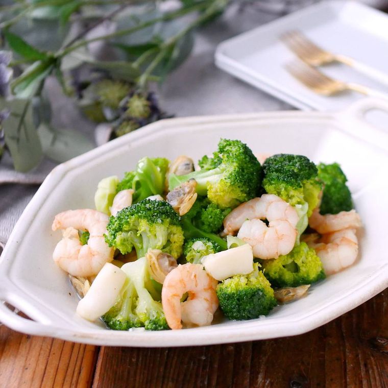 白い多角形プレートに盛りつけられたシーフードとブロッコリーのうま塩炒め