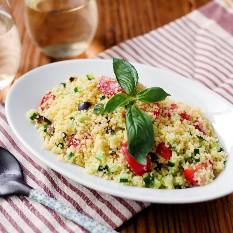 白いオーバル型のプレートに盛り付けられた、トマトときゅうりのクスクスサラダ