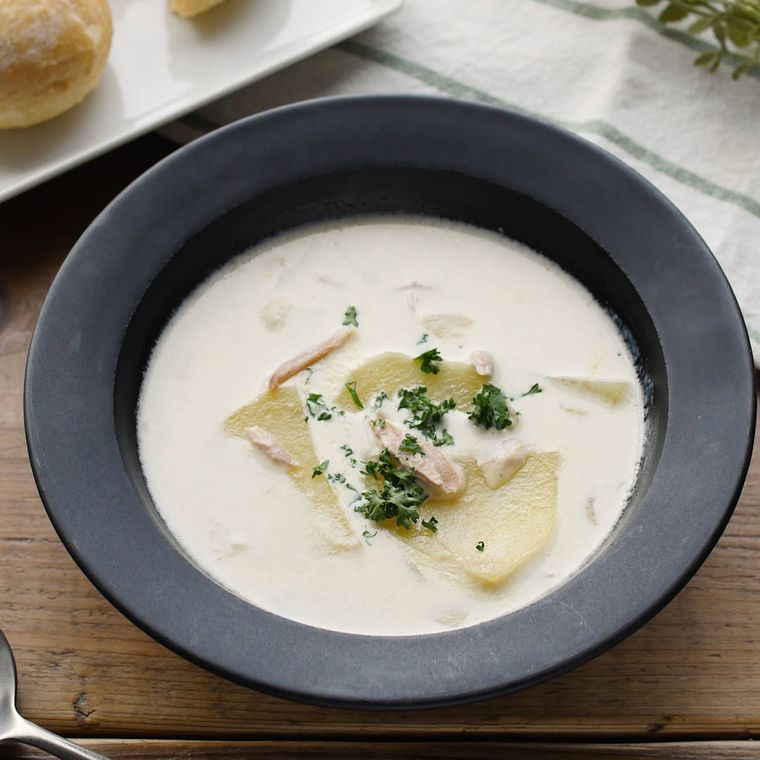 黒い皿に入った、じゃがいもとツナのクリームスープ