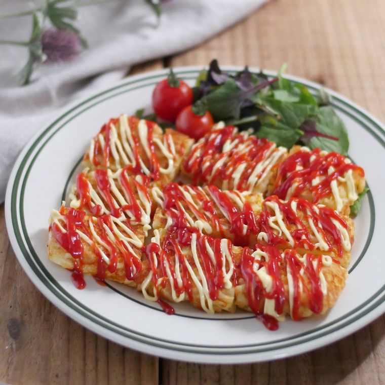 グレーのライン入りの白い丸皿に盛り付けた、ウインナーとチーズのチヂミ