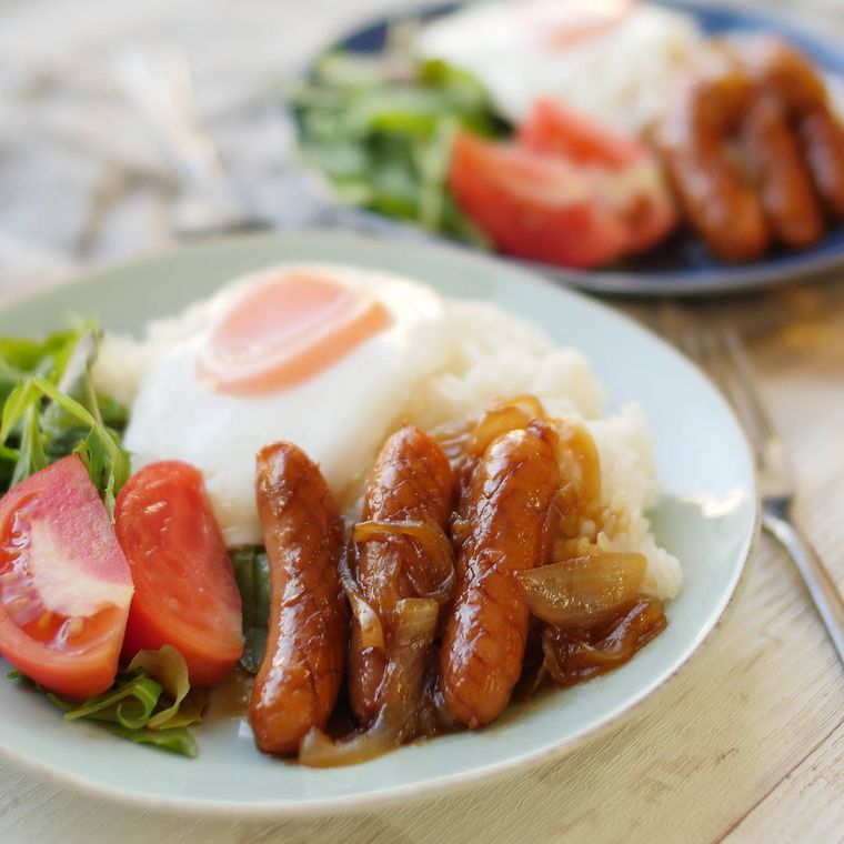 白い皿に入った、ウインナーのしょうが焼きと目玉焼き