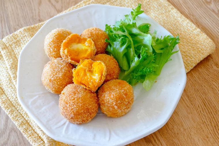 半分に切られたチーズ入りかぼちゃコロッケが盛られている大皿