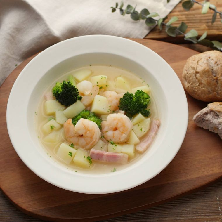 白いお皿に盛り付けたエビとブロッコリーのスープ