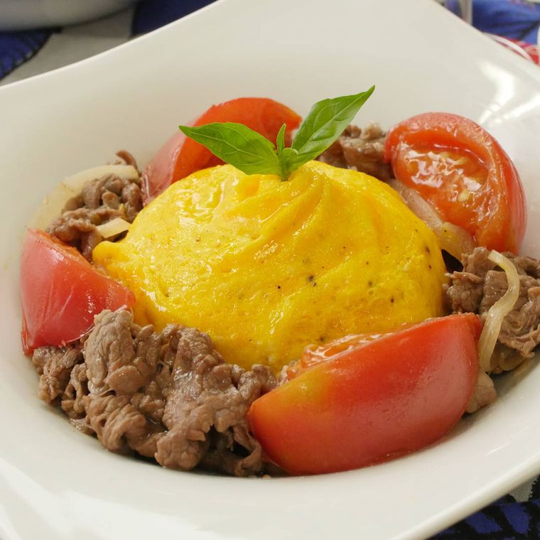 牛肉とトマトが添えられたドレス・ド・オムライス風の他人丼