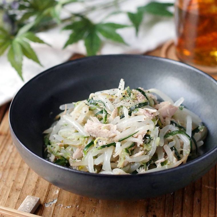 黒い丸皿にもやしときゅうりのナムルがのっている