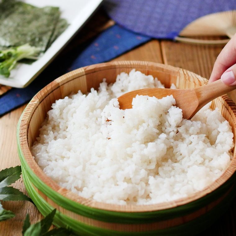 寿司桶に入った酢飯を、しゃもじですくう様子