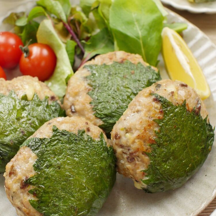 波模様の白い皿に盛りつけられたあじのチーズ入りなめろう焼き