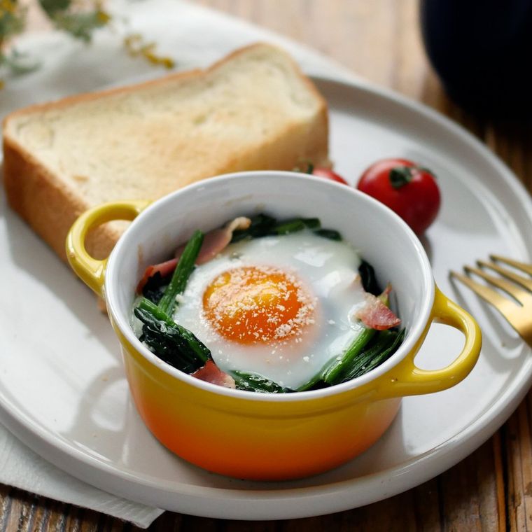 黄色とオレンジのカップに入ったほうれん草とベーコンのココット