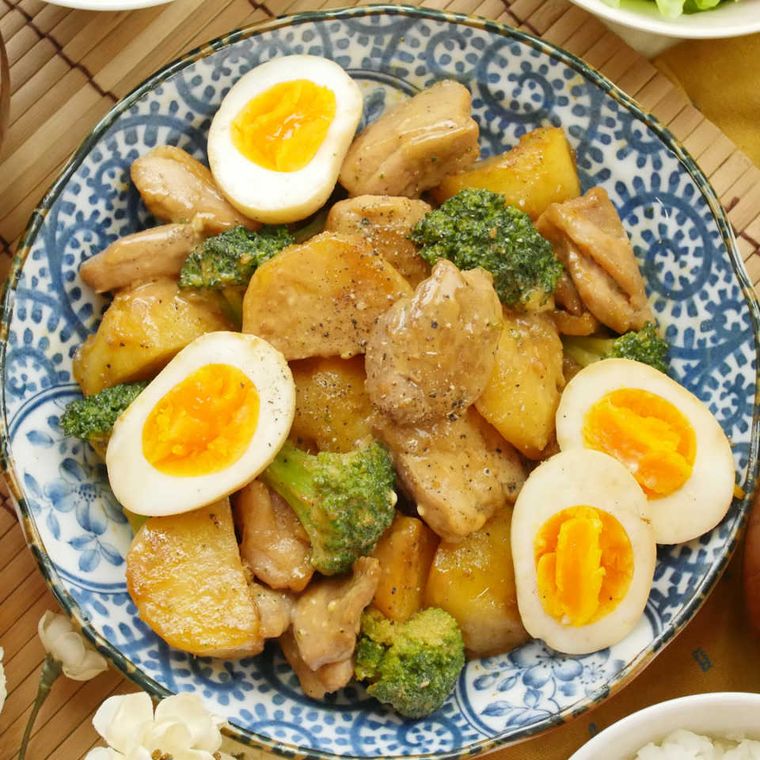 青い殻草模様の丸皿に盛られた鶏肉とじゃがいもの濃厚オイマヨ炒め