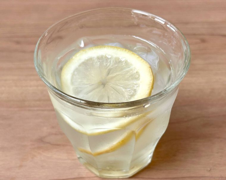 ガラスのコップにレモンの砂糖漬けの水割りが入っているところ