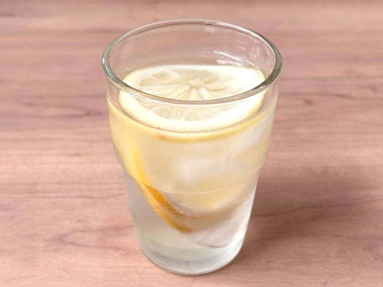 ガラスのコップにレモンの砂糖漬けの水割りが入っているところ