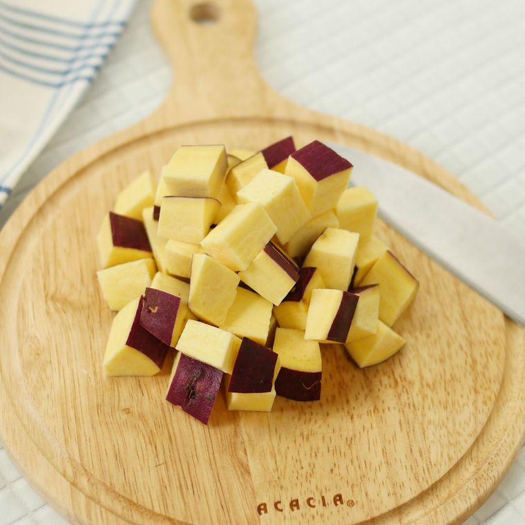 丸いカッティングボードの上で角切りされたさつまいも