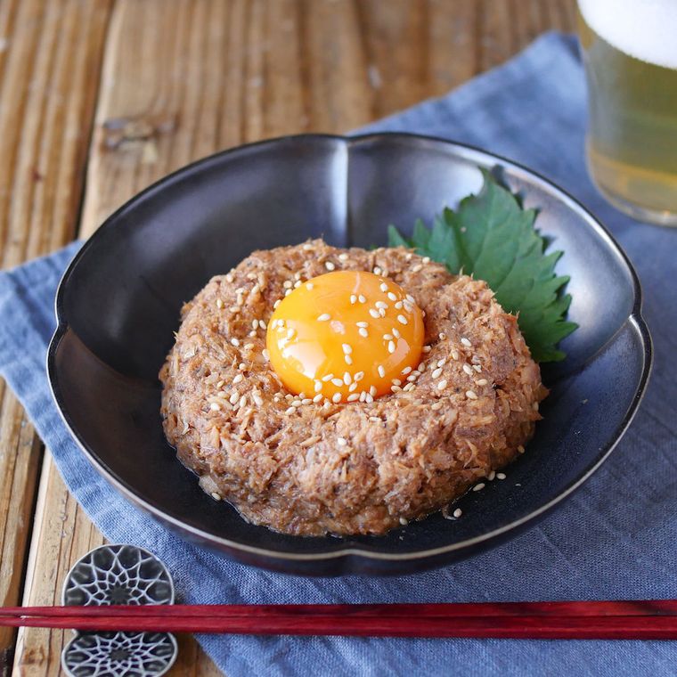 黒い皿に盛りつけられたさば水煮缶のユッケ風