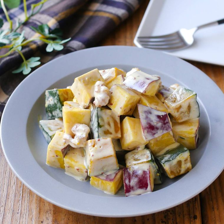 白い皿に盛りつけられたかぼちゃとさつまいものサラダ