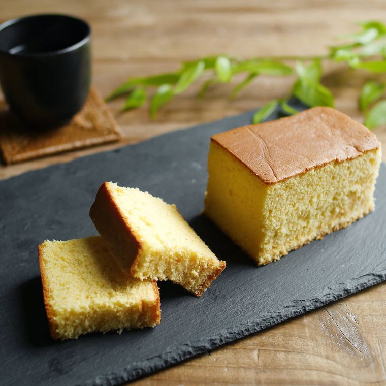 スレートプレートに盛りつけられているカステラをカットした様子