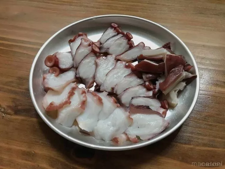 金属製の皿に盛りつけられているゆでだこの斜め薄切り