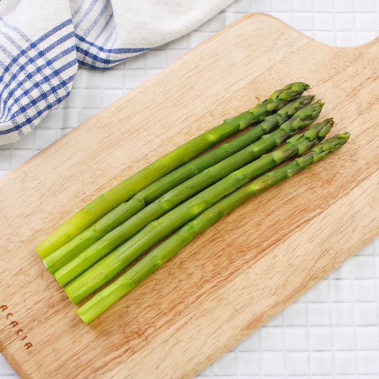カッティングボードの上に並べられている5本のアスパラガス