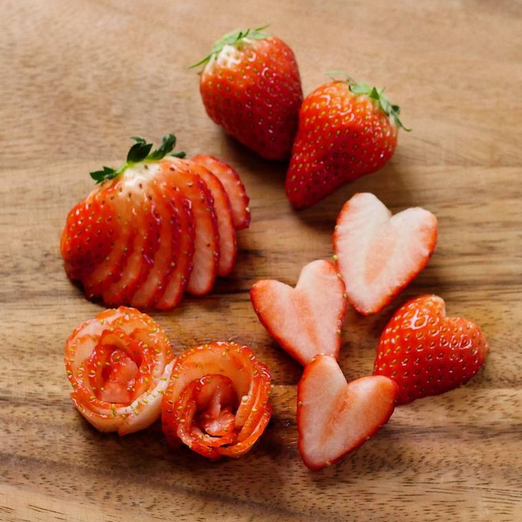 まな板の上で薄切りやローズ形、ハート形に飾り切りされたいちご