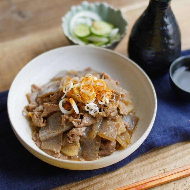 ベージュの皿に盛り付けられている牛こま肉とこんにゃくの煮込み