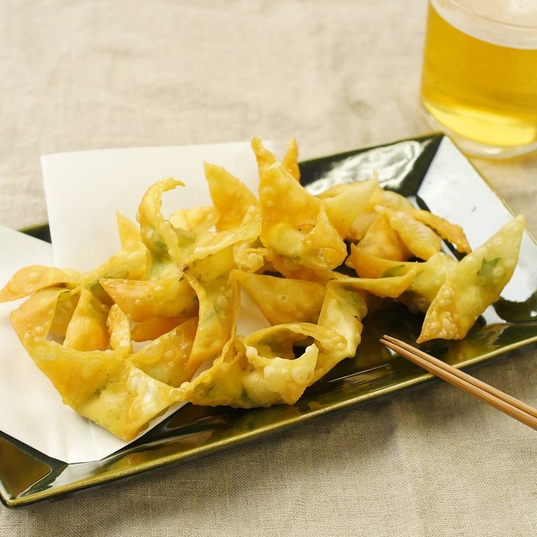 黒い皿に盛り付けられているクリームチーズと大葉の包み揚げ