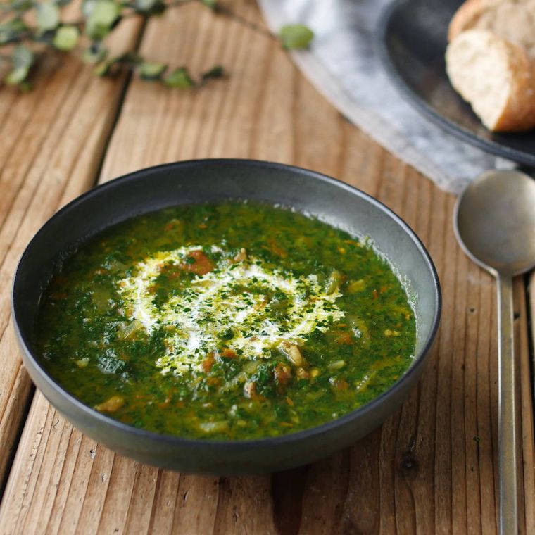 黒いボウルに入ったほうれん草のサグカレースープ