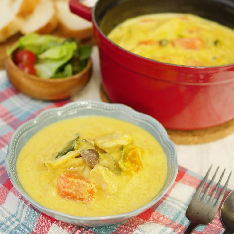 赤い鍋と皿に盛られた酒粕豆乳シチュー