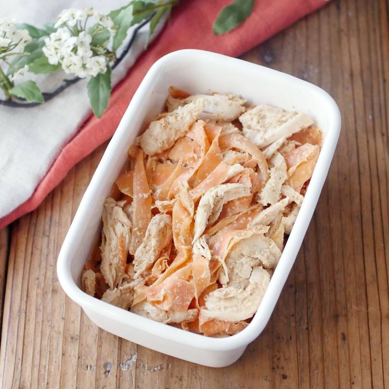 白い保存容器に入っている鶏ささみとにんじんのごまマヨサラダ