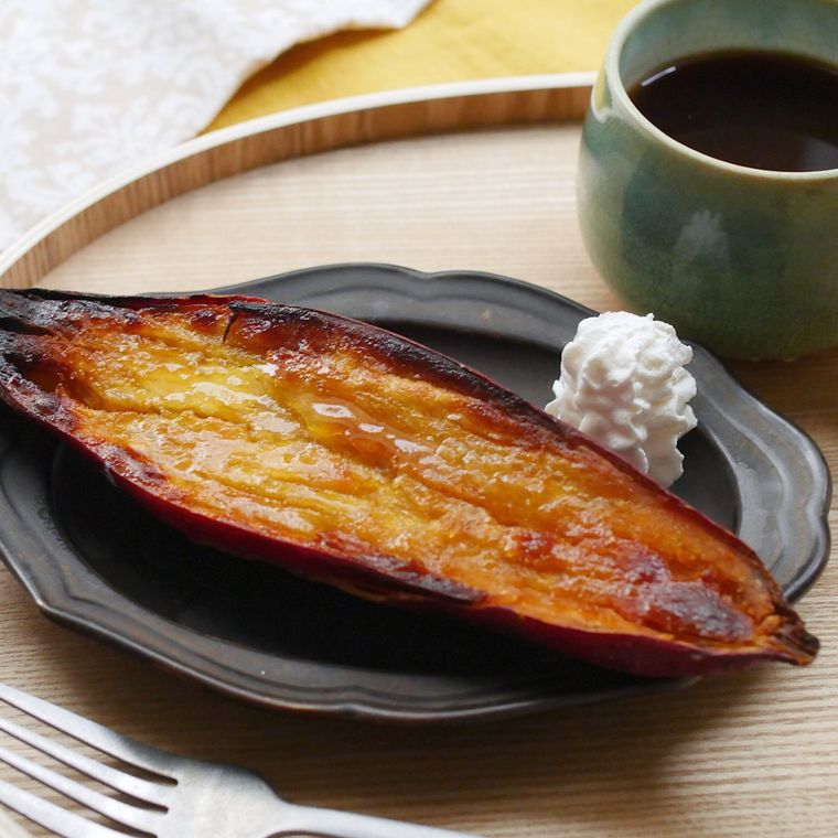 黒い皿に盛りつけられたブリュレスイートポテトに飲みものとフォークが添えられている