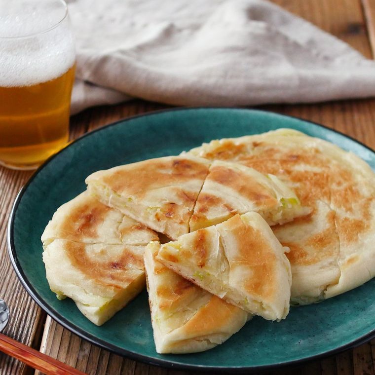 緑のプレートの上のチーズ葱油餅