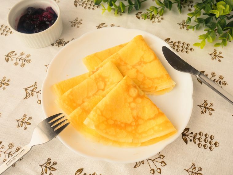 白い皿に並べたクレープ生地とココットに入ったベリーソース