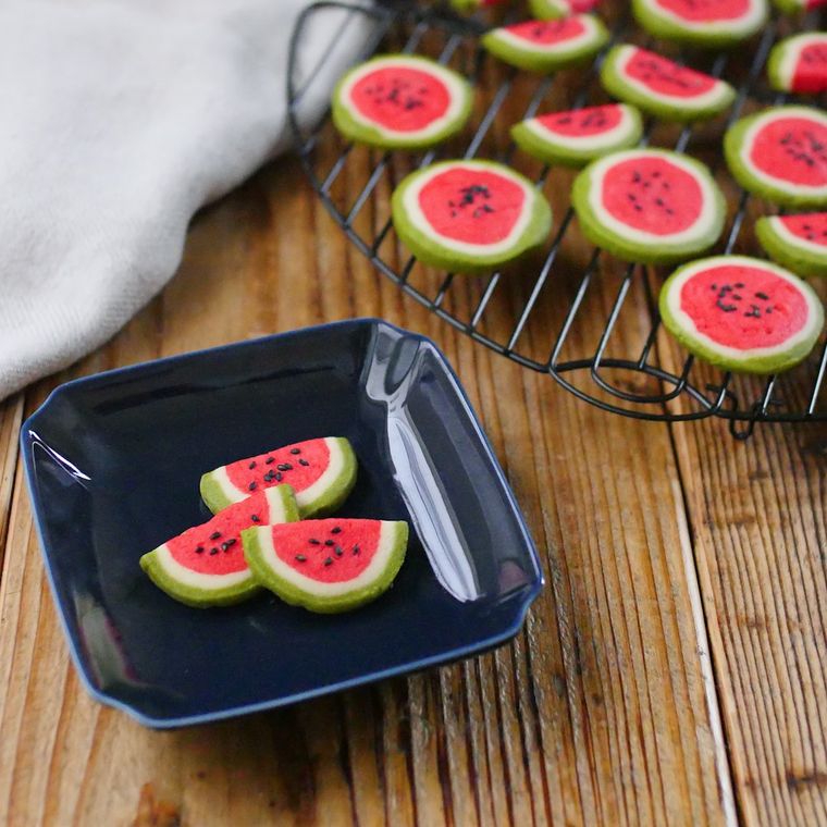黒い網と皿の上に盛られた、スイカのクッキー