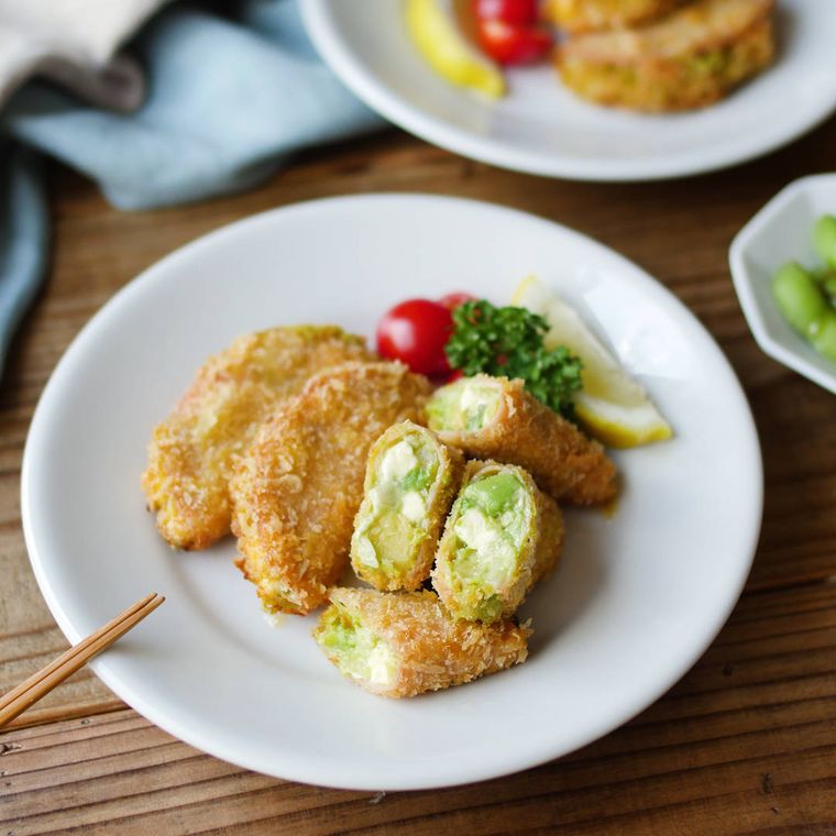 白い皿に盛りつけられたアボカドとクリームチーズ入りのハムカツ