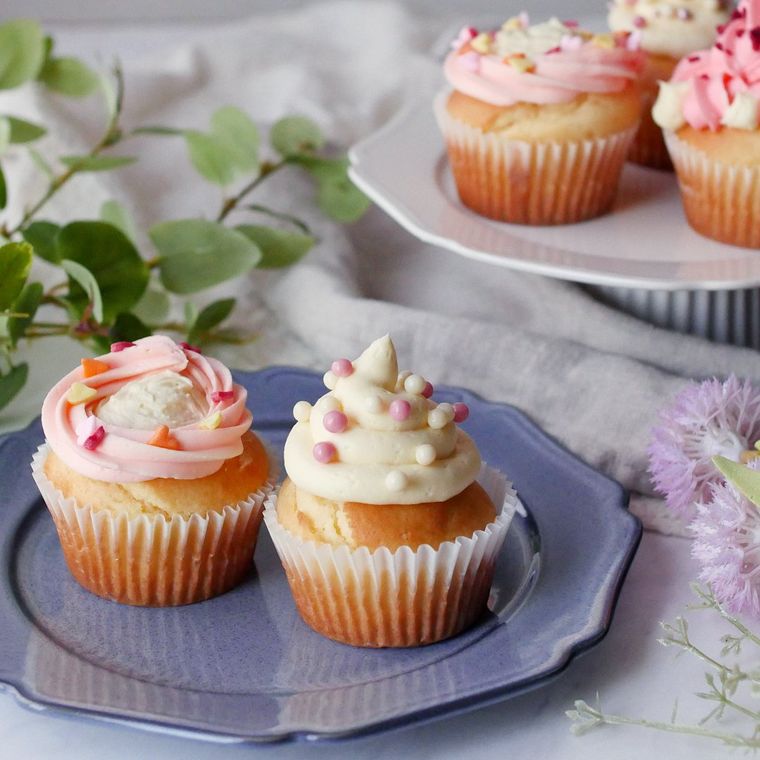 藍色の皿に盛られたクリームチーズのデコカップケーキ2種