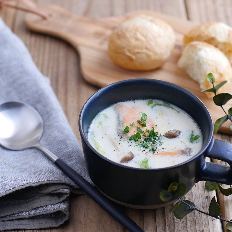 青い手付きカップに入った、鮭と白菜のクリームスープ