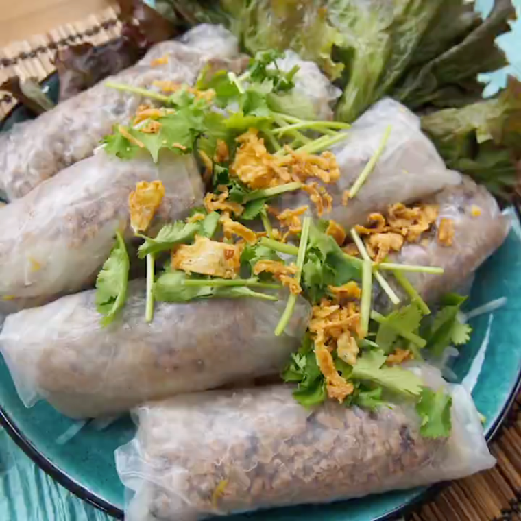 緑色の皿に盛られた、ヌクチャムソースの蒸し春巻き